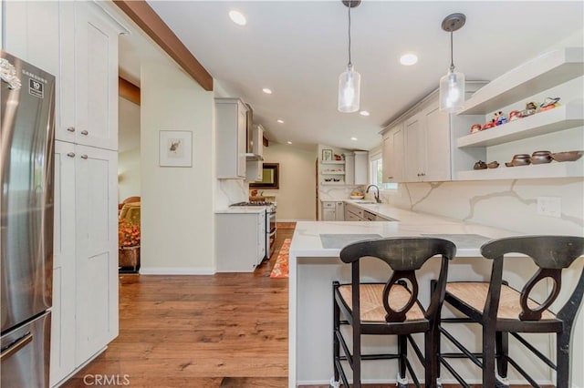 5276 Willow Wood Rd, Rolling Hills Estates, CA 90274 - kitchen with double oven range, open shelves, freestanding refrigerator, wood finished floors, and a breakfast bar area