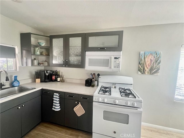 2226 Evans Dr, Arrowbear, CA 92382 - kitchen with white appliances, light wood-style floors, glass insert cabinets, light countertops, and open shelves