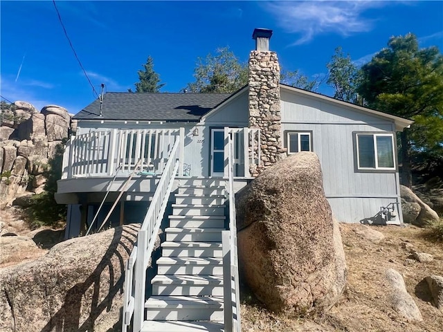 2226 Evans Dr, Arrowbear, CA 92382 - rear view of house with stairs, a shingled roof, a deck, and a chimney