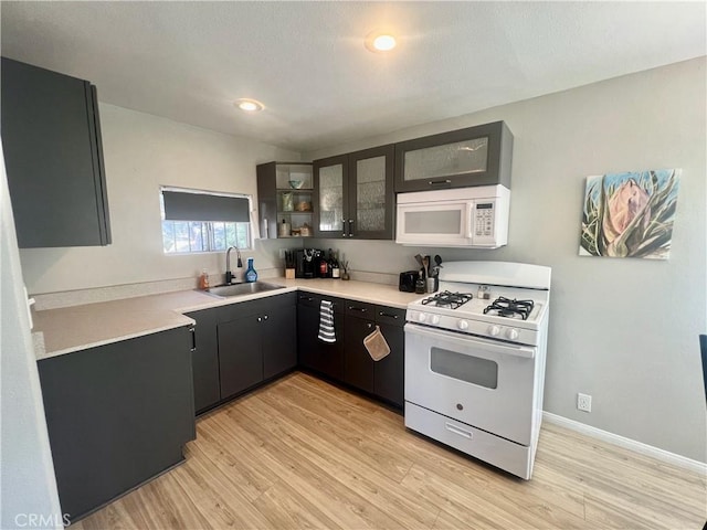 2226 Evans Dr, Arrowbear, CA 92382 - kitchen featuring white appliances, light wood-style floors, glass insert cabinets, light countertops, and dark cabinetry