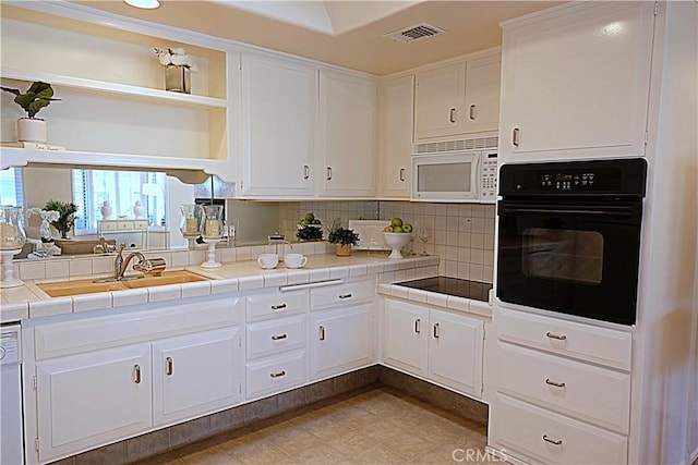 1681 Tam Oshanter Rd Unit 10C M12, Seal Beach, CA 90740 - kitchen with black appliances, open shelves, white cabinetry, tasteful backsplash, and tile countertops