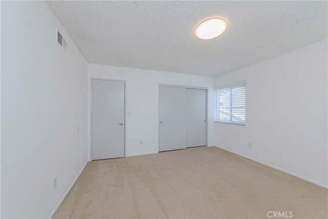 2406 Descanso Way, Torrance, CA 90504 - unfurnished bedroom with light carpet, a textured ceiling, and a closet