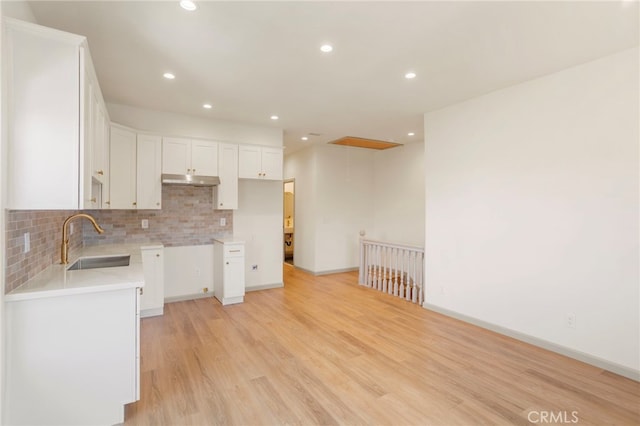 1241 W 22nd St, Los Angeles, CA 90007 - kitchen with light wood-type flooring, tasteful backsplash, recessed lighting, white cabinets, and under cabinet range hood