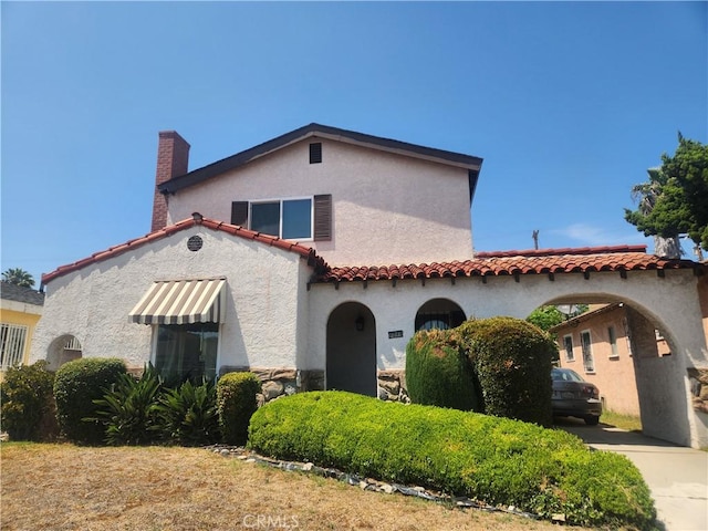 1019 W 84th St, Los Angeles, CA 90044 - mediterranean / spanish-style home featuring stucco siding, a tile roof, and a chimney