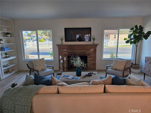 24921 Cypress St, Lomita, CA 90717 - living area featuring wood finished floors, healthy amount of natural light, and a stone fireplace