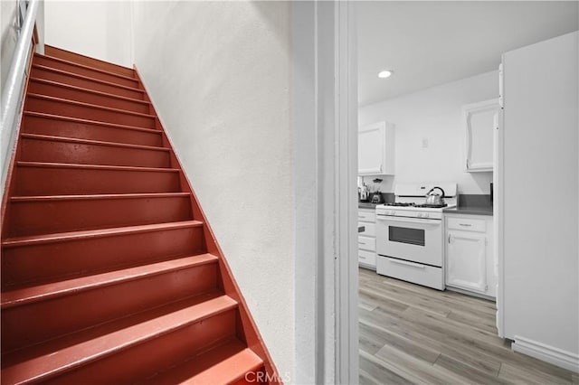 1067 N Wilton Pl, Los Angeles, CA 90038 - stairs with wood finished floors and recessed lighting