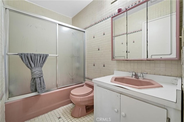 1067 N Wilton Pl, Los Angeles, CA 90038 - bathroom with tile walls, vanity, bath / shower combo with glass door, tile patterned flooring, and backsplash