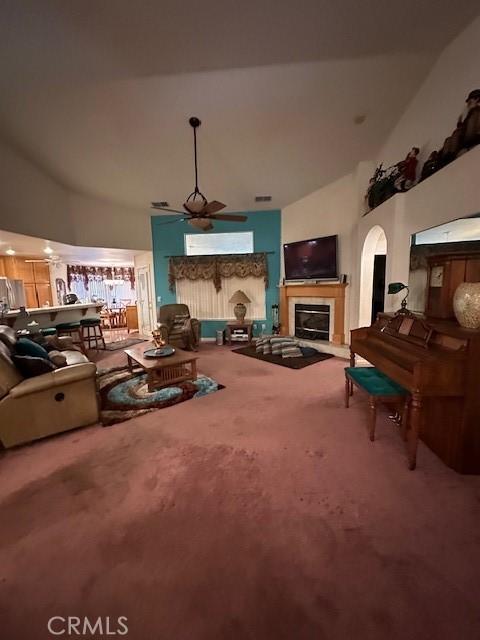 3854 Canvasback Ct, Merced, CA 95340 - carpeted living room featuring a glass covered fireplace, high vaulted ceiling, and arched walkways