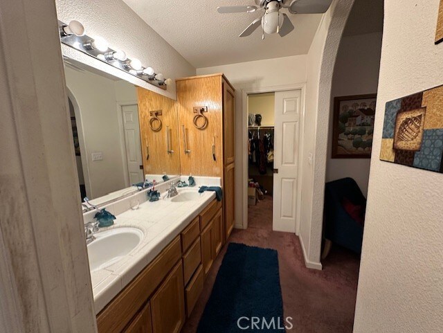 3854 Canvasback Ct, Merced, CA 95340 - bathroom featuring a textured wall, a ceiling fan, and double vanity