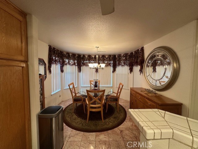 3854 Canvasback Ct, Merced, CA 95340 - dining space with a chandelier and a textured ceiling