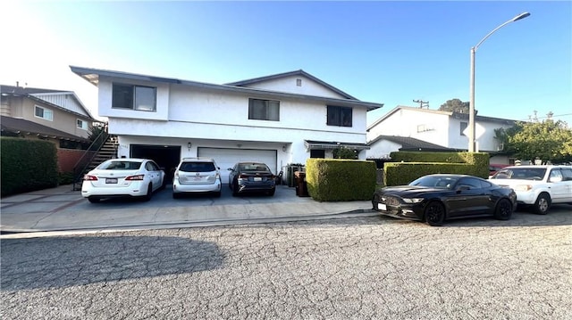 11053 Elmcrest St, El Monte, CA 91731 - view of front of property featuring an attached garage, concrete driveway, stairway, and stucco siding