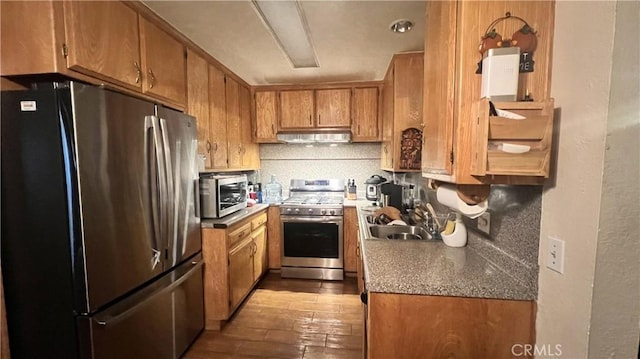 11053 Elmcrest St, El Monte, CA 91731 - kitchen with appliances with stainless steel finishes, under cabinet range hood, hardwood / wood-style flooring, brown cabinetry, and decorative backsplash