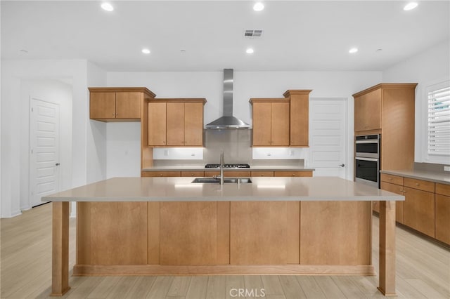 11937 Wandering Way, Corona, CA 92883 - kitchen featuring wall chimney exhaust hood, double oven, light wood-type flooring, a spacious island, and light countertops