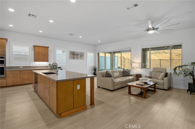 11937 Wandering Way, Corona, CA 92883 - kitchen with open floor plan, a ceiling fan, appliances with stainless steel finishes, light wood finished floors, and an island with sink
