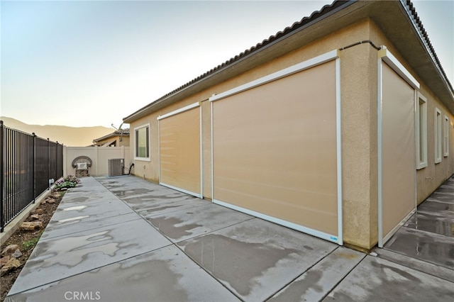 11937 Wandering Way, Corona, CA 92883 - view of side of home with a fenced backyard, a patio area, a tiled roof, and stucco siding