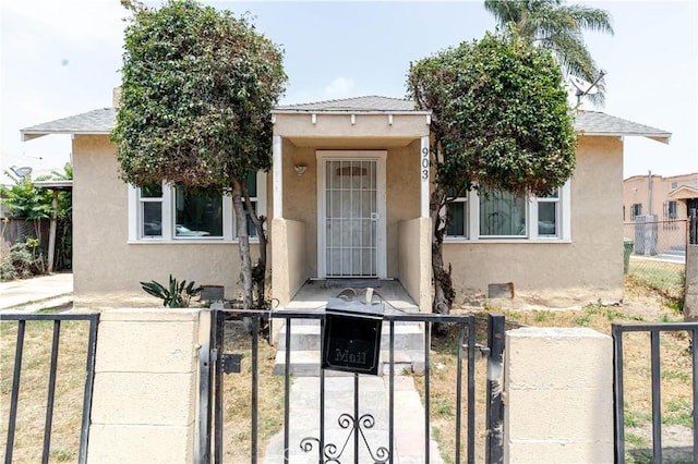 903 W 84th St, Los Angeles, CA 90044 - view of front of property with stucco siding, a fenced front yard, and a gate