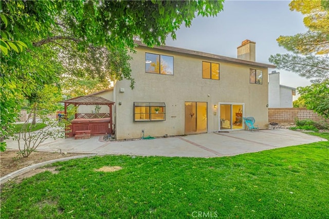 44118 Ruthron Ave, Lancaster, CA 93536 - back of property featuring a chimney, a gazebo, a patio, a hot tub, and stucco siding