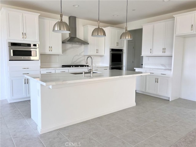 17727 Santa Lucia Ct, Riverside, CA 92503 - kitchen featuring wall chimney range hood, double oven, white cabinets, light countertops, and a center island with sink