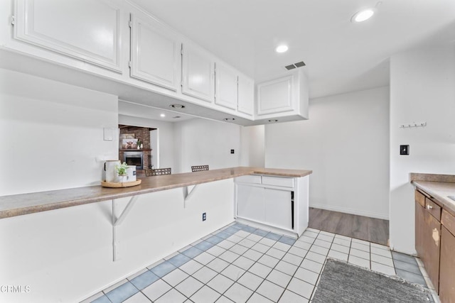 1904 N 7th St, Port Hueneme, CA 93041 - kitchen with a brick fireplace, white cabinets, light tile patterned flooring, light countertops, and recessed lighting