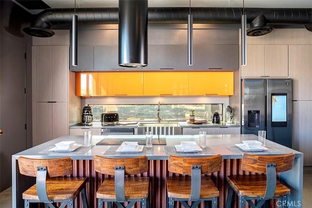 6640 Mount Shasta Ave, Joshua Tree, CA 92252 - kitchen featuring stainless steel refrigerator with ice dispenser, modern cabinets, light countertops, and a kitchen bar