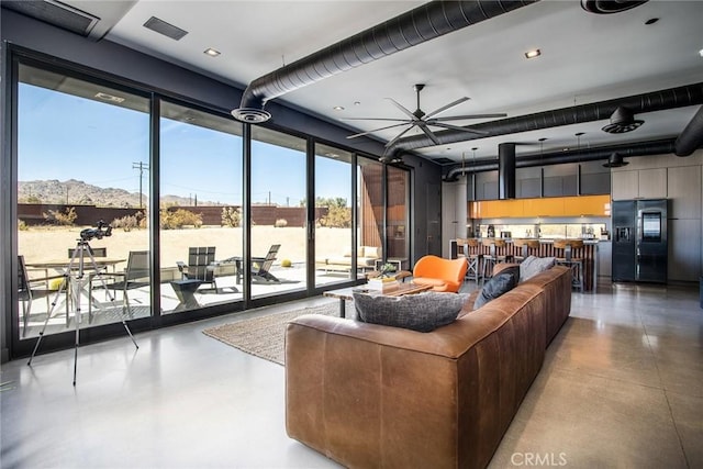 6640 Mount Shasta Ave, Joshua Tree, CA 92252 - living room with concrete floors, a ceiling fan, and floor to ceiling windows