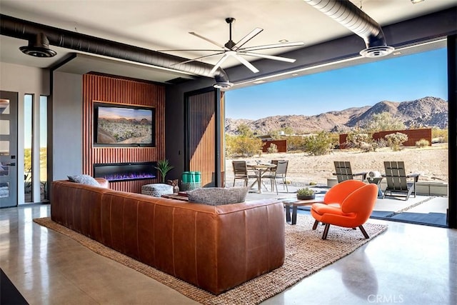 6640 Mount Shasta Ave, Joshua Tree, CA 92252 - living area featuring concrete floors, ceiling fan, plenty of natural light, and floor to ceiling windows
