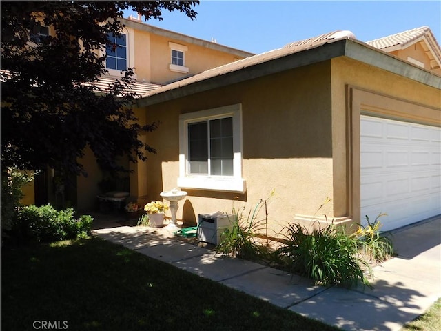 12405 Firefly Way, Victorville, CA 92392 - view of property exterior with stucco siding and a garage