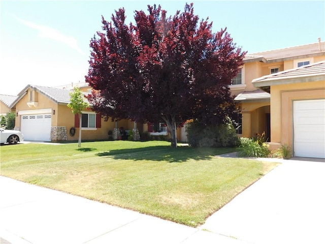 12405 Firefly Way, Victorville, CA 92392 - view of front of home featuring a garage, stucco siding, a front yard, and stone siding