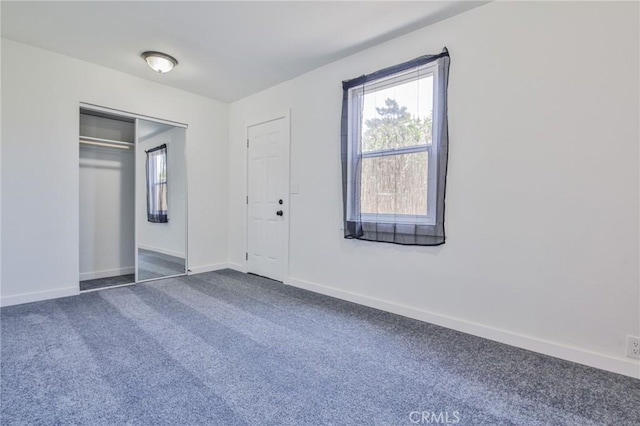 1964 E 114th St, Los Angeles, CA 90059 - unfurnished bedroom featuring multiple windows, dark colored carpet, and a closet