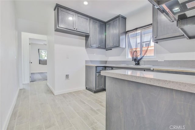 1964 E 114th St, Los Angeles, CA 90059 - kitchen with healthy amount of natural light, gray cabinetry, recessed lighting, and light stone counters