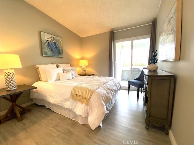 1441 Monterey Rd Unit M2-61J, Seal Beach, CA 90740 - bedroom featuring access to exterior, wood finished floors, lofted ceiling, and a textured ceiling
