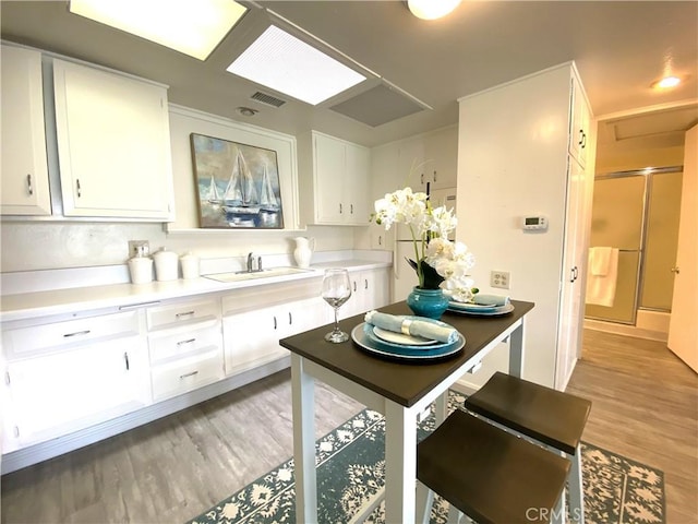 1441 Monterey Rd Unit M2-61J, Seal Beach, CA 90740 - kitchen featuring white cabinetry, light wood-style flooring, and light countertops
