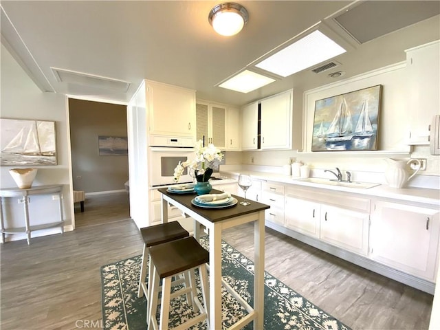 1441 Monterey Rd Unit M2-61J, Seal Beach, CA 90740 - kitchen featuring light countertops, wood finished floors, and white cabinetry