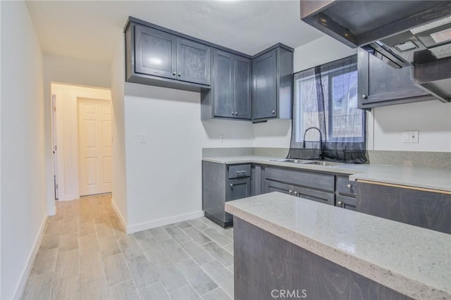 1962 E 114th St, Los Angeles, CA 90059 - kitchen featuring extractor fan, light wood-style flooring, and light stone countertops