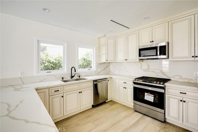 1038 N Columbus Ave, Glendale, CA 91202 - kitchen with stainless steel appliances, light stone counters, light wood-style floors, and decorative backsplash