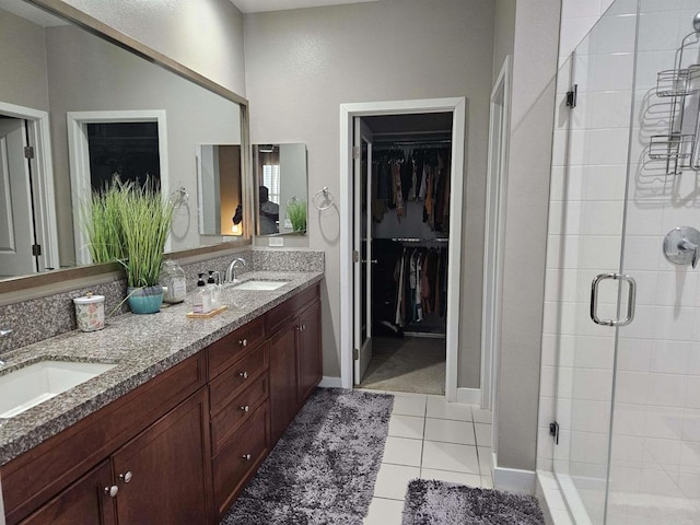 7508 Eagle Dr, Santee, CA 92071 - bathroom featuring a stall shower, double vanity, a spacious closet, and tile patterned floors