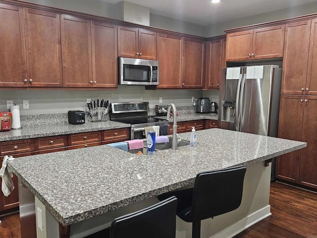 7508 Eagle Dr, Santee, CA 92071 - kitchen with stainless steel appliances, dark wood-style flooring, a kitchen bar, an island with sink, and recessed lighting