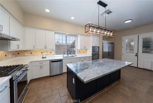 125 W Franklin Ave, Ridgecrest, CA 93555 - kitchen featuring stainless steel appliances, stone tile flooring, a center island, under cabinet range hood, and white cabinetry