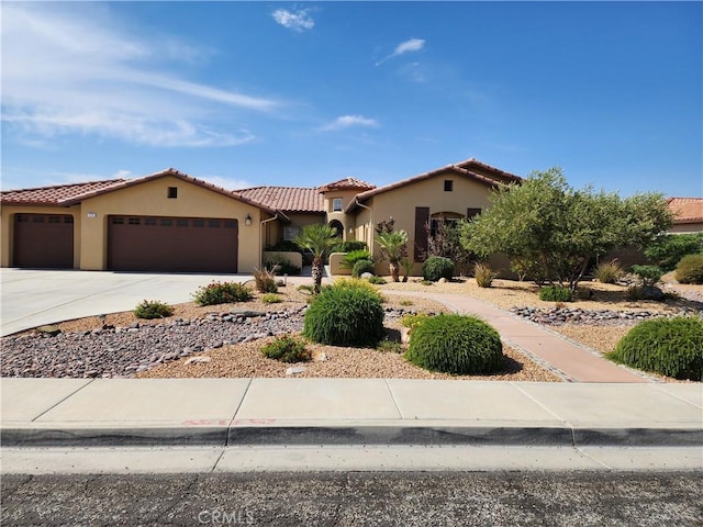 125 W Franklin Ave, Ridgecrest, CA 93555 - mediterranean / spanish-style house featuring a garage, a tile roof, concrete driveway, and stucco siding