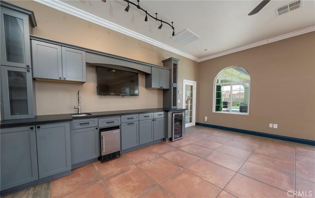 125 W Franklin Ave, Ridgecrest, CA 93555 - kitchen featuring wine cooler, dark countertops, crown molding, light tile patterned floors, and track lighting