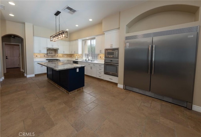 125 W Franklin Ave, Ridgecrest, CA 93555 - kitchen featuring built in appliances, stone tile floors, a center island, white cabinetry, and recessed lighting