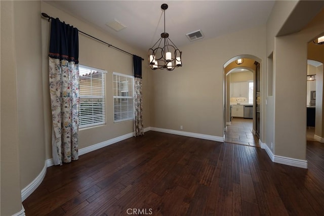 125 W Franklin Ave, Ridgecrest, CA 93555 - unfurnished dining area featuring arched walkways, a chandelier, and dark wood-type flooring