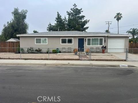 942 Front St, Perris, CA 92570 - ranch-style home with a garage, a fenced front yard, and driveway