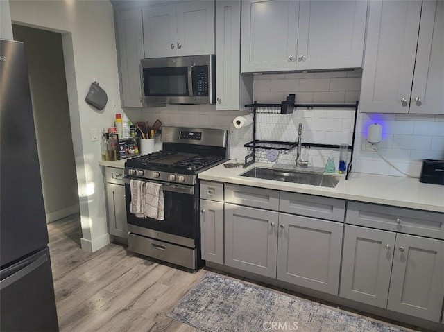 942 Front St, Perris, CA 92570 - kitchen featuring stainless steel appliances, gray cabinets, light wood-style flooring, light countertops, and tasteful backsplash