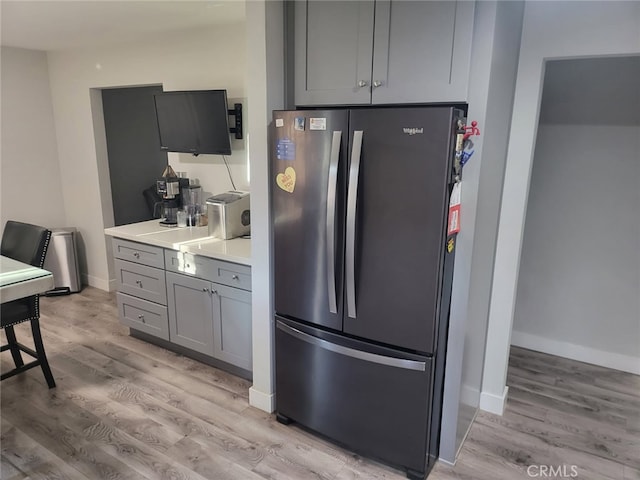 942 Front St, Perris, CA 92570 - kitchen with freestanding refrigerator, gray cabinetry, light wood finished floors, and light countertops