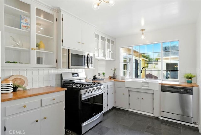 1872 Tulane Ave, Long Beach, CA 90815 - kitchen featuring stainless steel appliances, backsplash, light countertops, white cabinets, and glass insert cabinets