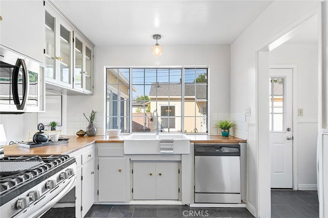 1872 Tulane Ave, Long Beach, CA 90815 - kitchen with stainless steel appliances, white cabinets, glass insert cabinets, dark tile patterned floors, and light countertops