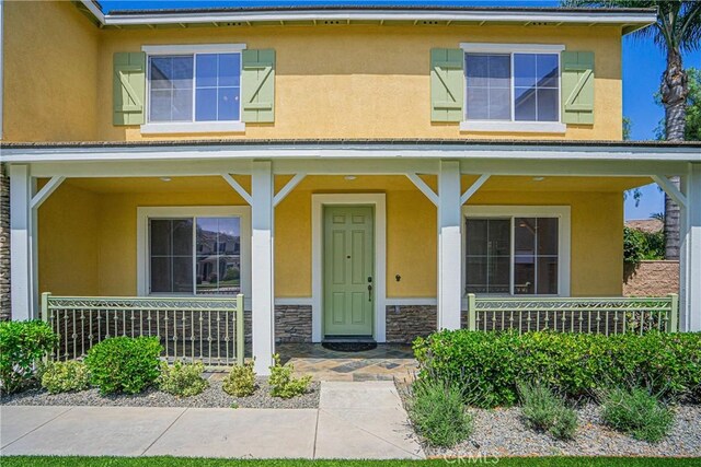 6221 Ruby Crest Way, Jurupa Valley, CA 91752 - view of front of property with stucco siding, a porch, and stone siding