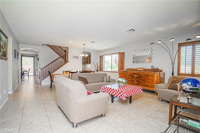 6221 Ruby Crest Way, Jurupa Valley, CA 91752 - living area with stairway, light tile patterned floors, arched walkways, a chandelier, and plenty of natural light