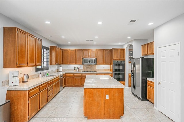 6221 Ruby Crest Way, Jurupa Valley, CA 91752 - kitchen featuring stainless steel appliances, a center island, light countertops, brown cabinets, and recessed lighting